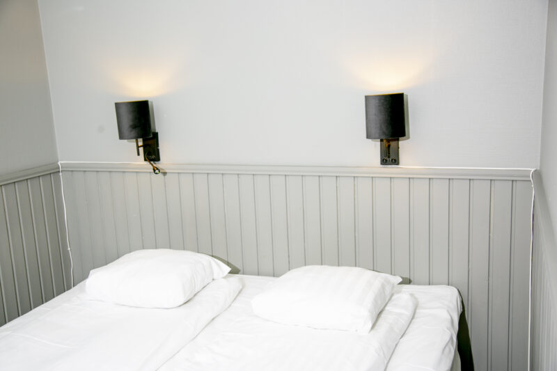 Rymligt rum på Hotel Expo i Stockholm med två enkelsängar, våningssängar, TV och mjuk sänggavel – utformat för större sällskap eller familjer med tillgång till bastu